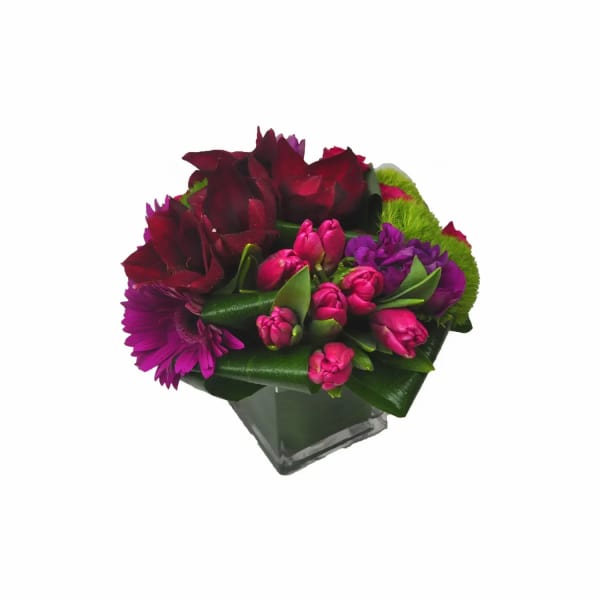 Bouquet of burgundy and pink flowers in a square glass vase