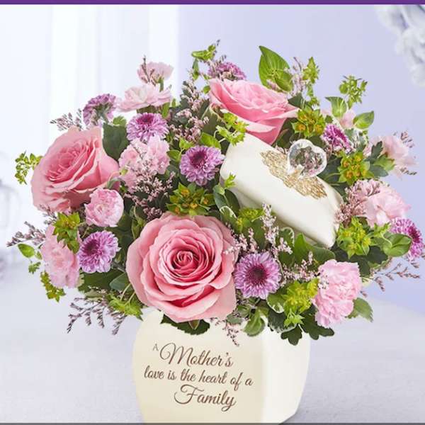 Pink roses and purple mums in a cream keepsake vase with a lidded trinket box.