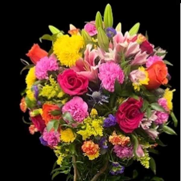 Tall mixed flower arrangement in a rectangular bark-textured container