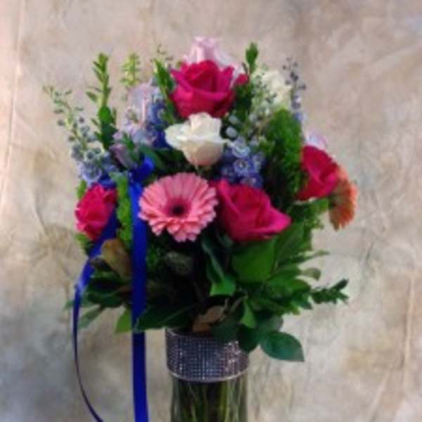 Bouquet of pink and white roses with a pink gerbera in a tall glass vase