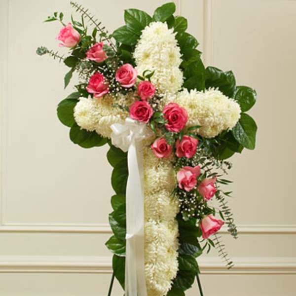 Standing floral spray with pink roses and white flowers on a white ribboned easel