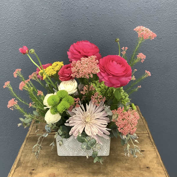 Mixed bouquet in a patterned rectangular vase with pink, white, and green blooms