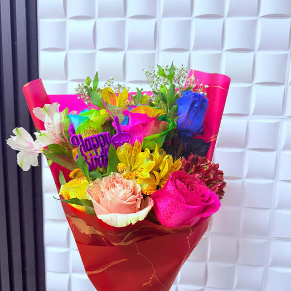 Bright mixed bouquet with roses and alstroemeria in red wrapping