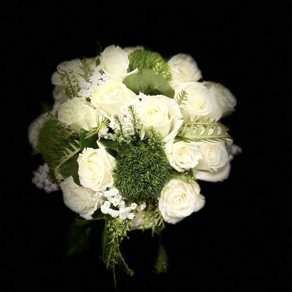 White rose bouquet with green accents on a black background