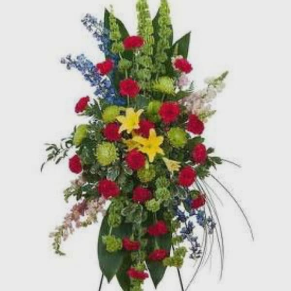 Tall standing floral spray with red, yellow, blue, and green flowers
