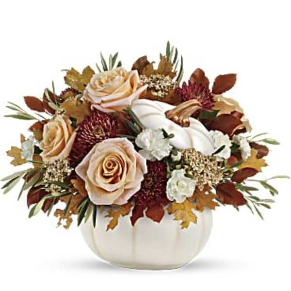 Autumn floral arrangement with roses and a white pumpkin in a white vase