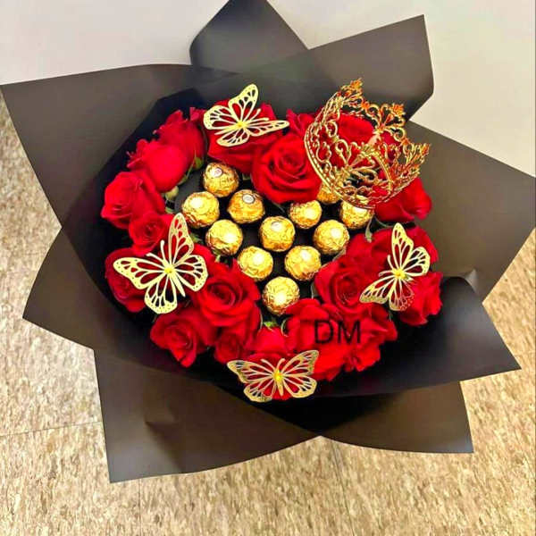 Red roses arranged with gold-wrapped chocolates in black paper