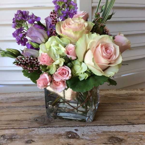Pink and lavender roses in a clear glass vase