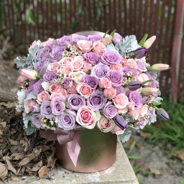Lavender and pink rose bouquet in a round hatbox with ribbon