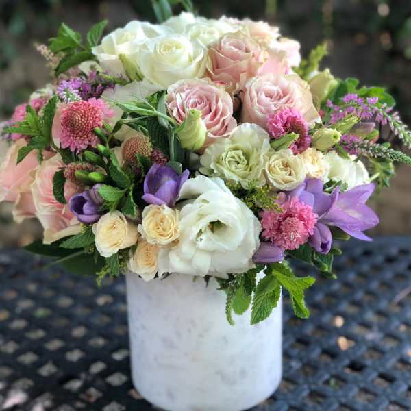Bouquet of pink, white, and purple flowers in a white vase
