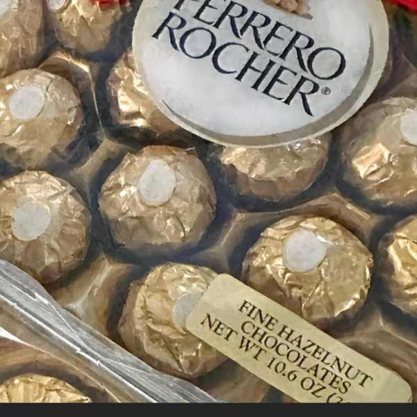 Boxed Ferrero Rocher chocolates with gold wrappers and a pink ribbon