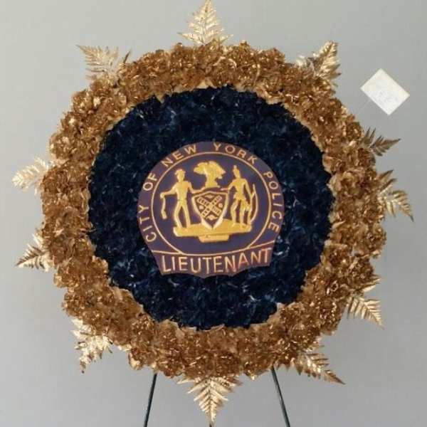 Circular floral tribute with a New York Police Lieutenant emblem in the center