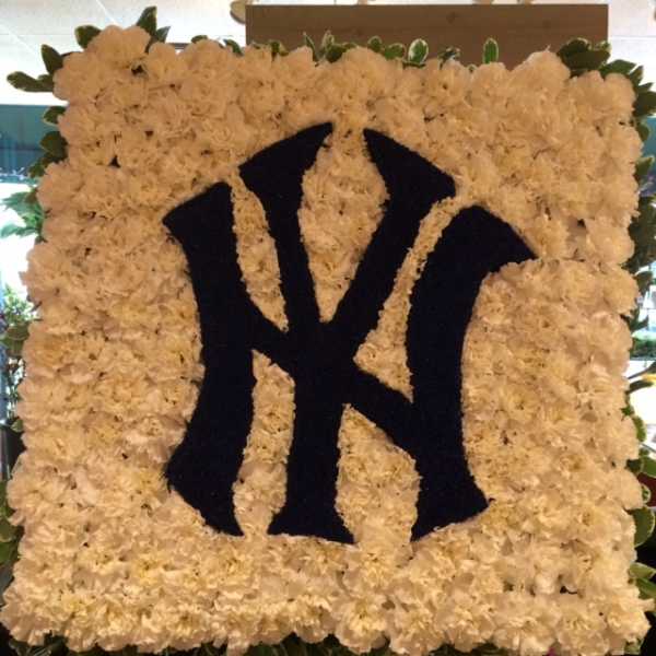 Square white floral tribute with a black New York Yankees logo
