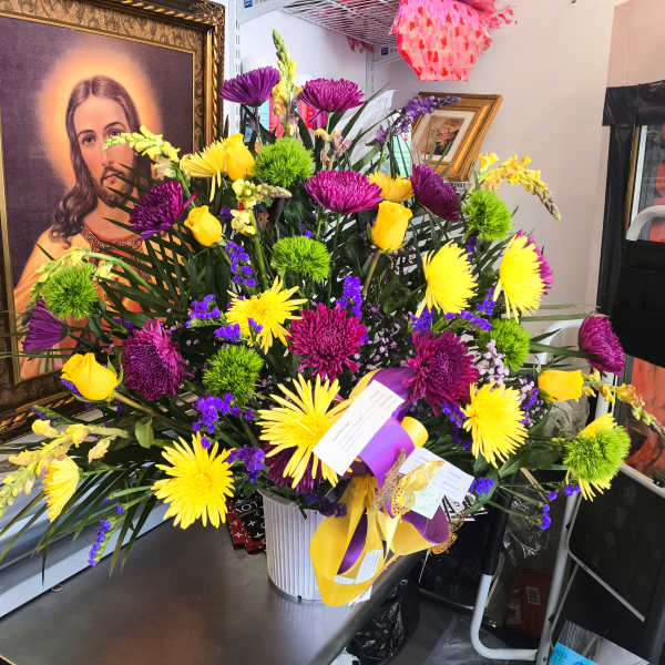 Bright mixed bouquet in a white vase with yellow and purple flowers