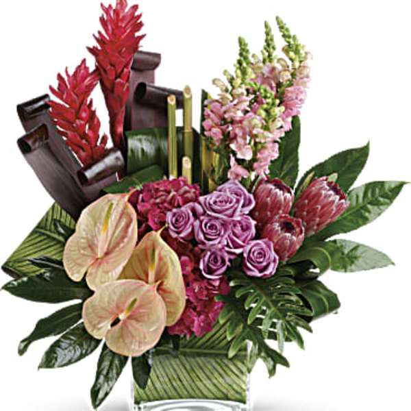 Tropical floral arrangement with pink roses and anthuriums in a glass vase