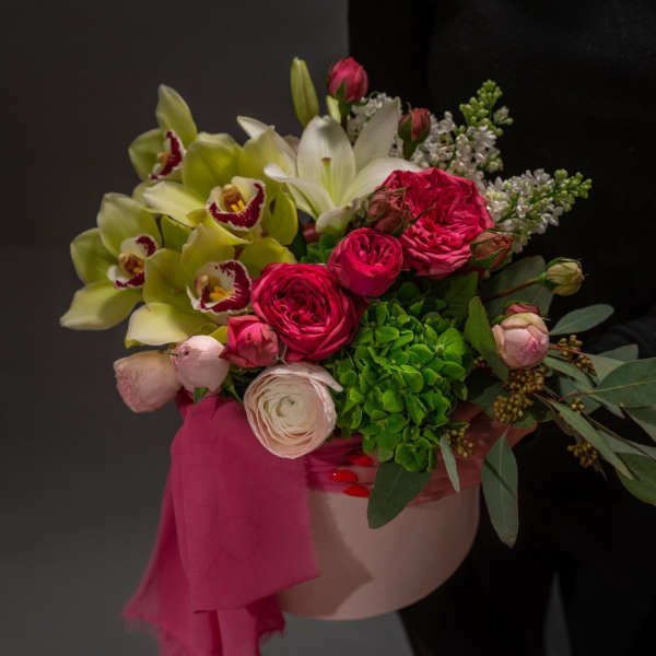 Bouquet of pink roses, orchids, and white lilies in a pink hat box