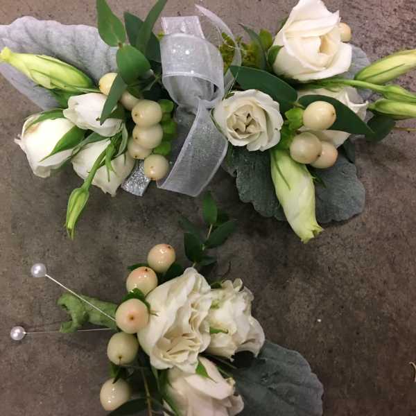 White floral corsage and boutonniere with ribbon and pearl accents