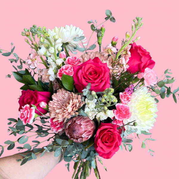 Handheld bouquet of pink roses, chrysanthemums, and carnations