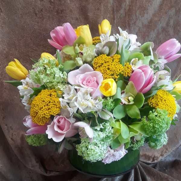 Mixed bouquet of pink and yellow tulips with roses in a green vase