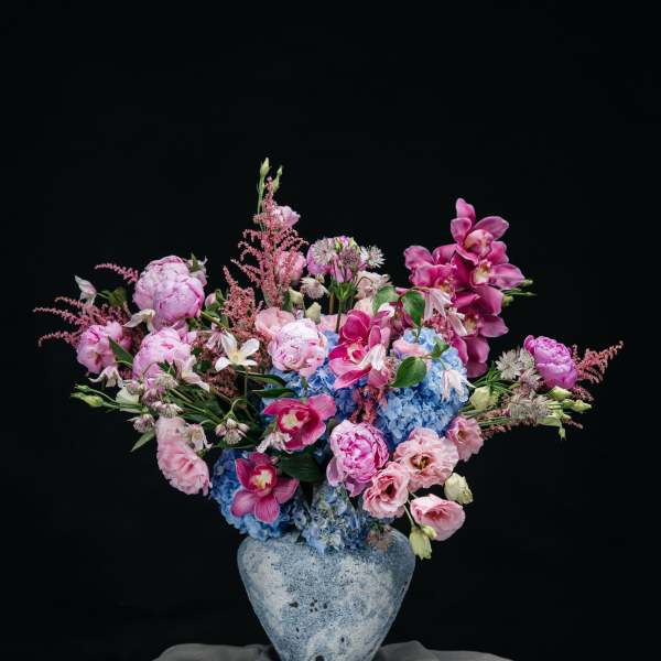 Pink and blue floral arrangement in a ceramic vase