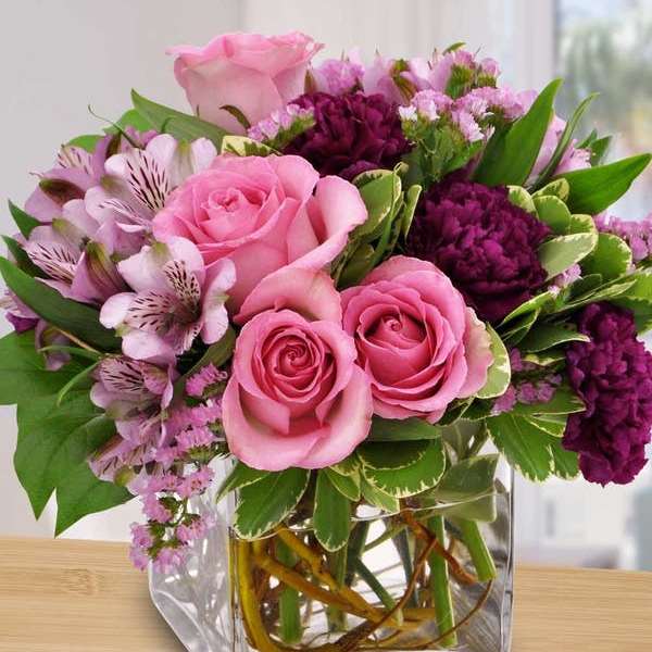 Pink and purple flower bouquet in a clear glass vase