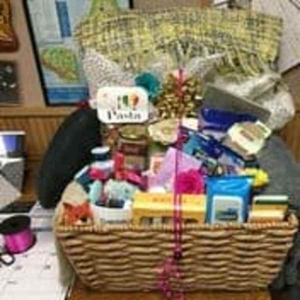 Gift basket with assorted packaged items and a pink ribbon