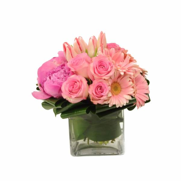 Pink mixed flower arrangement in a clear square vase
