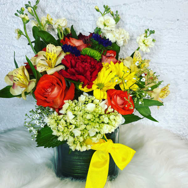 Mixed bouquet in a dark vase with a yellow ribbon