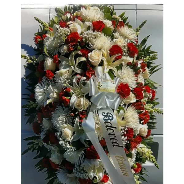 Large red and white funeral spray with ribbon on an easel