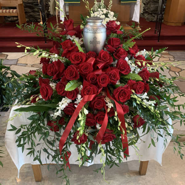 Red rose funeral spray with a silver urn centerpiece