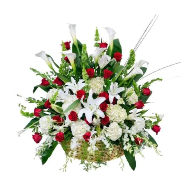 Basket arrangement of red roses and white calla lilies