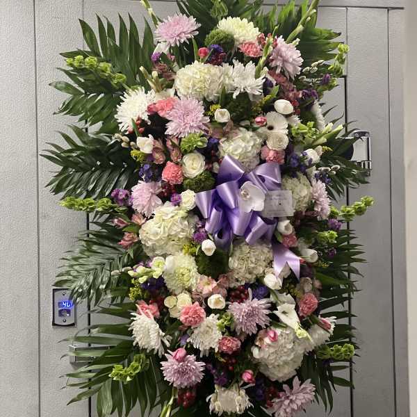 Large standing floral spray with pink, white, and purple blooms