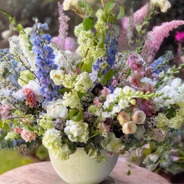 Mixed bouquet of pastel flowers in a white vase