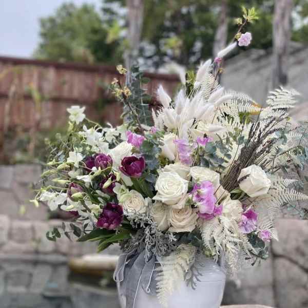 Bouquet of white and purple flowers in a white vase
