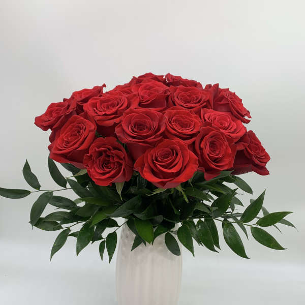 Red roses arranged in a white vase
