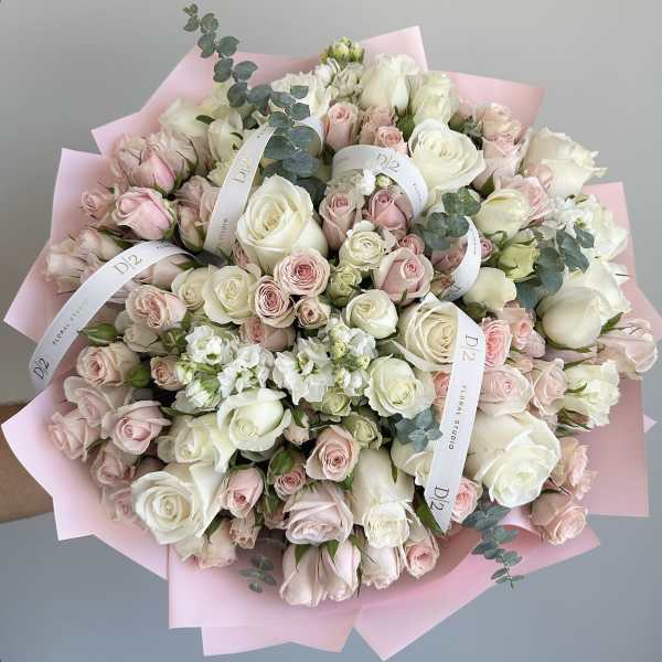Large bouquet of white and blush roses wrapped in pink paper