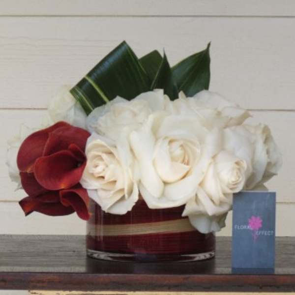 White and red roses arranged in a low glass vase