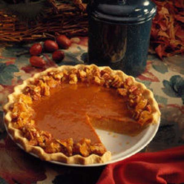 Pumpkin pie on a plate with a slice removed