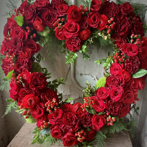 Heart-shaped wreath of red roses with berry accents