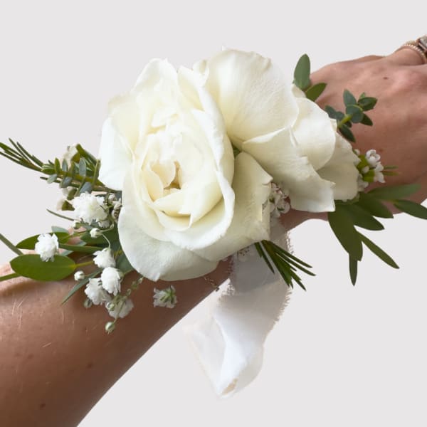 White rose wrist corsage with small white filler flowers
