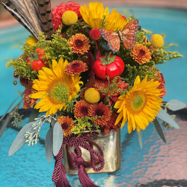 Autumn bouquet with sunflowers, mums, and decorative pumpkins in a metal vase
