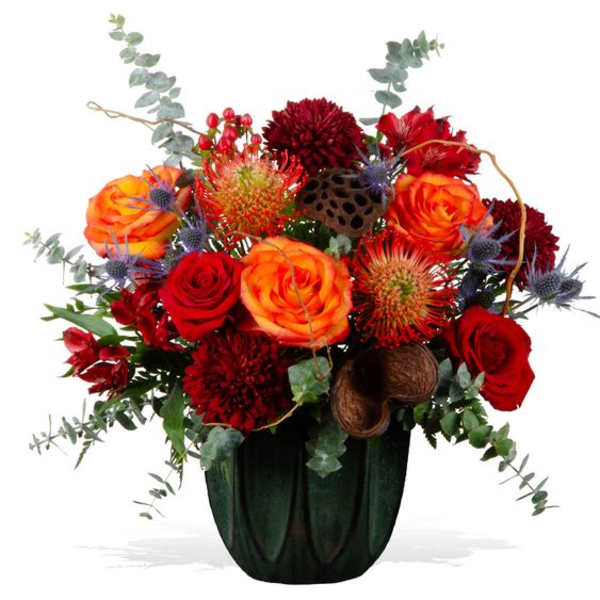 Red and orange floral arrangement in a dark vase