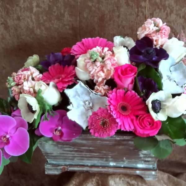 Pink and white mixed flower arrangement in a rectangular vase