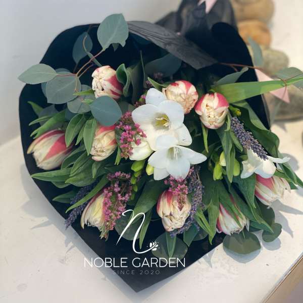 Bouquet of white and pink flowers wrapped in black paper