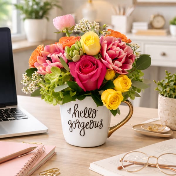 Mixed bouquet in a white mug with pink, yellow, and orange flowers