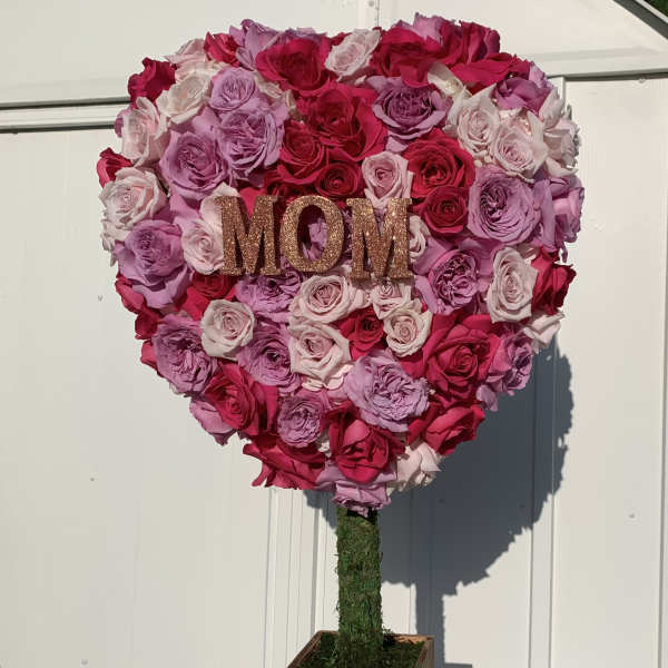 Heart-shaped rose arrangement with a glittery MOM sign on a wooden stand