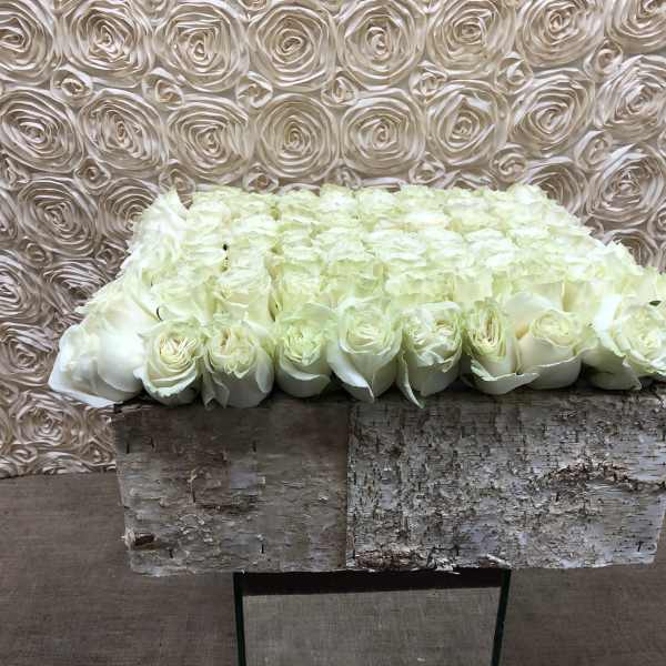 White rose arrangement in a rustic birch box