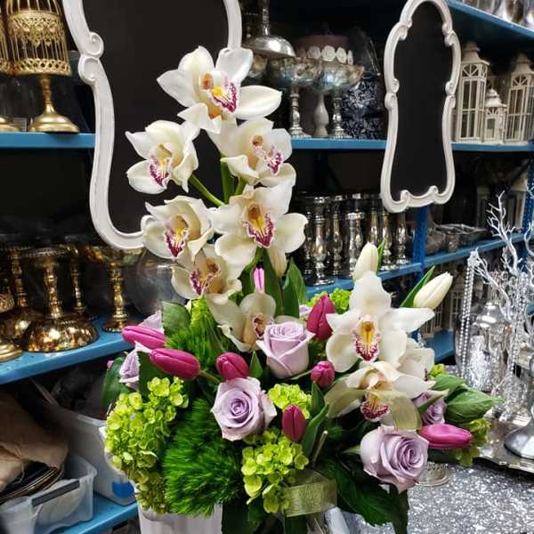 White orchids and lavender roses in a vase with pink tulips