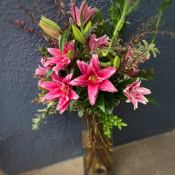 Pink lilies arranged in a tall glass vase