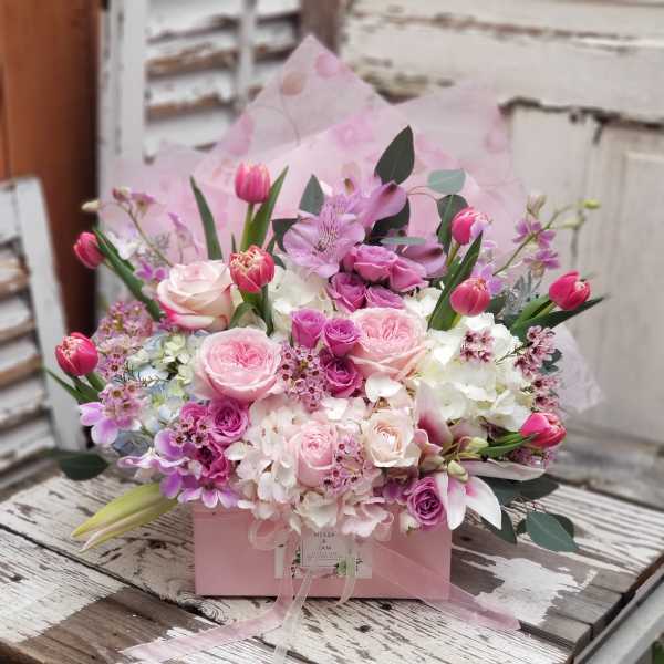 Pink and lavender bouquet in a pink box with ribbon